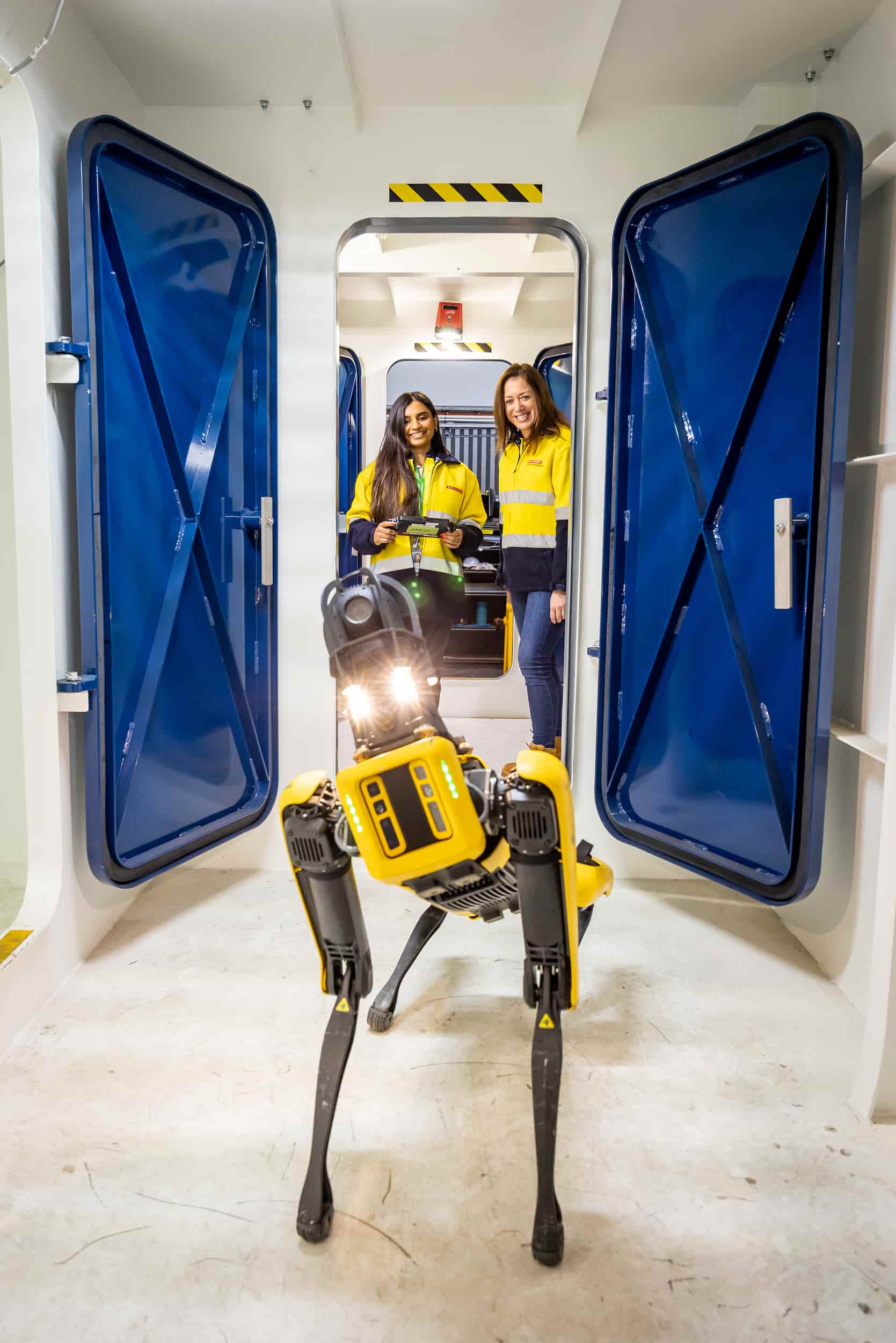 Two young women operating a quadraped robot