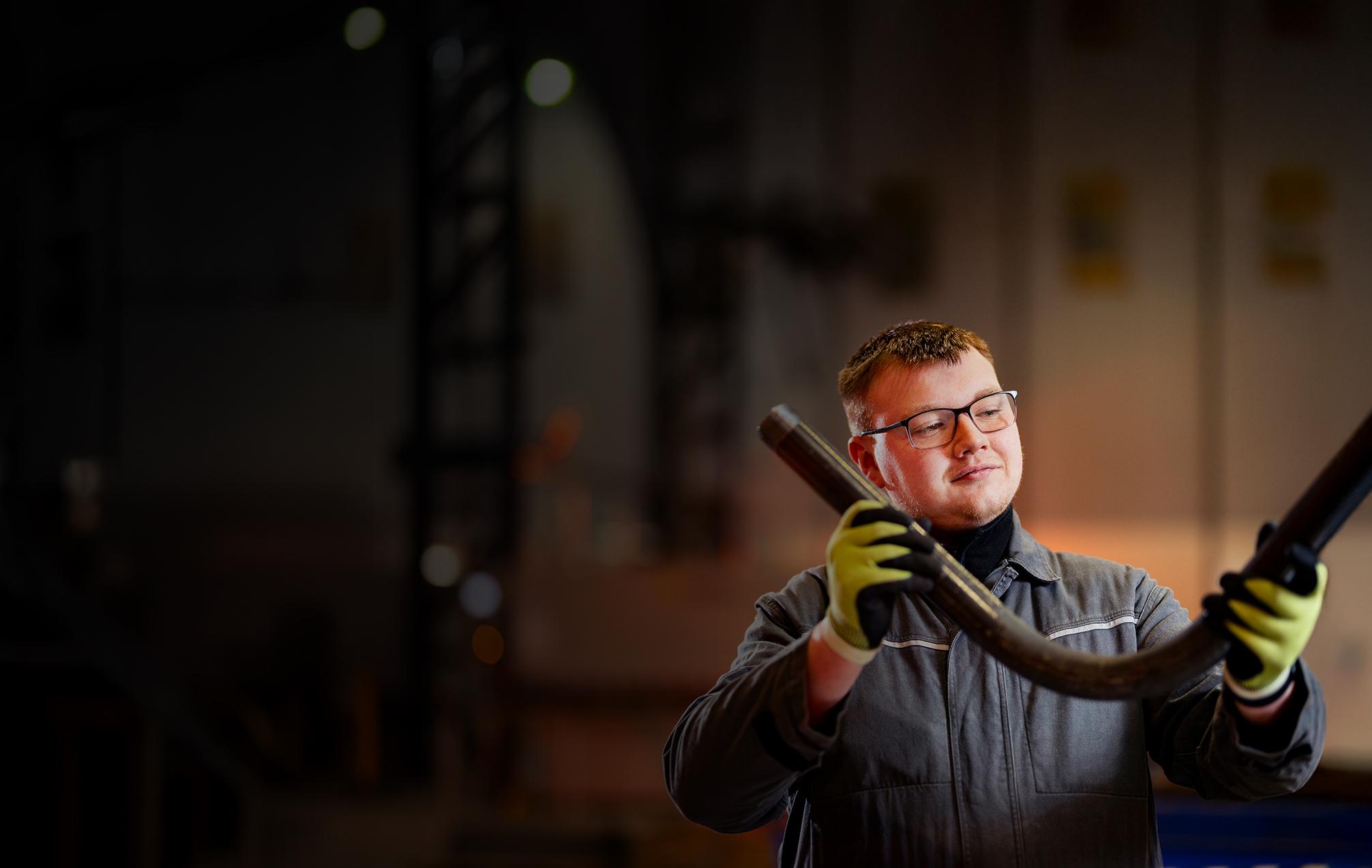 Employee holding pipe