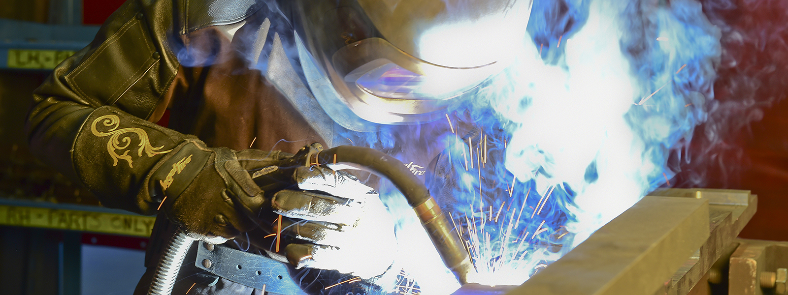 Sparks fly has a welder completes a welding assignment