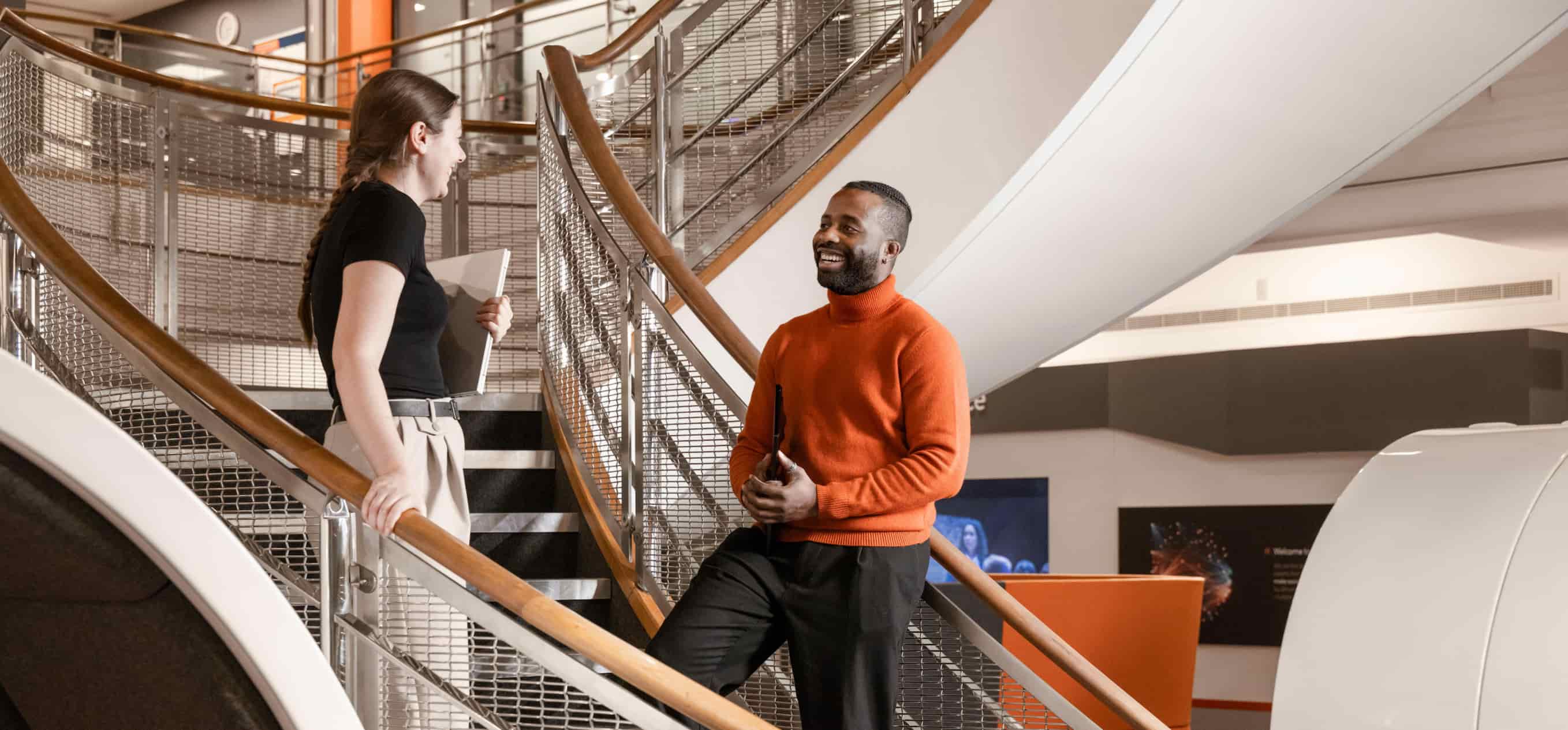 Two project managers at BAE Systems having a meeting on a stairwell