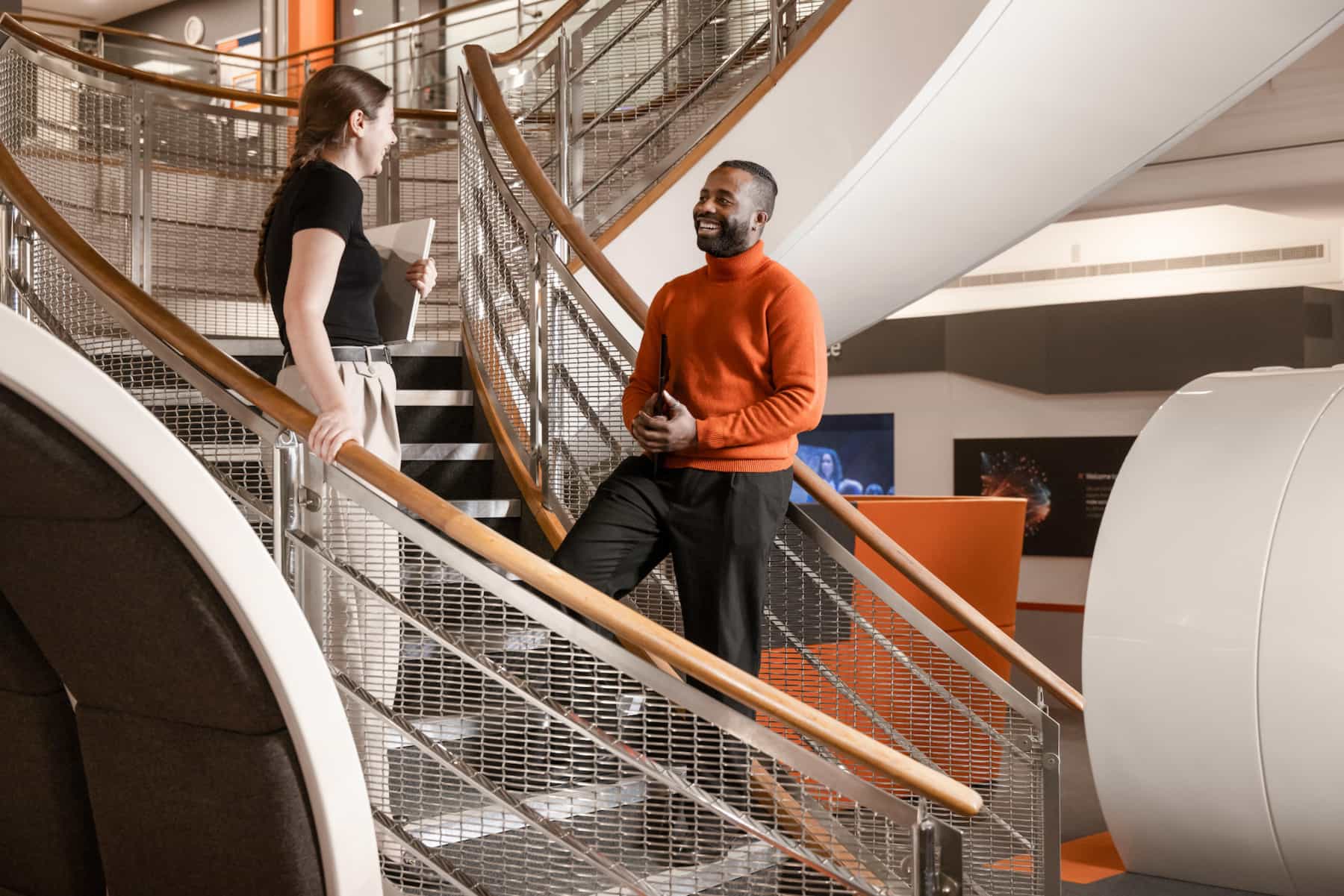 Two project managers at BAE Systems having a meeting on a stairwell