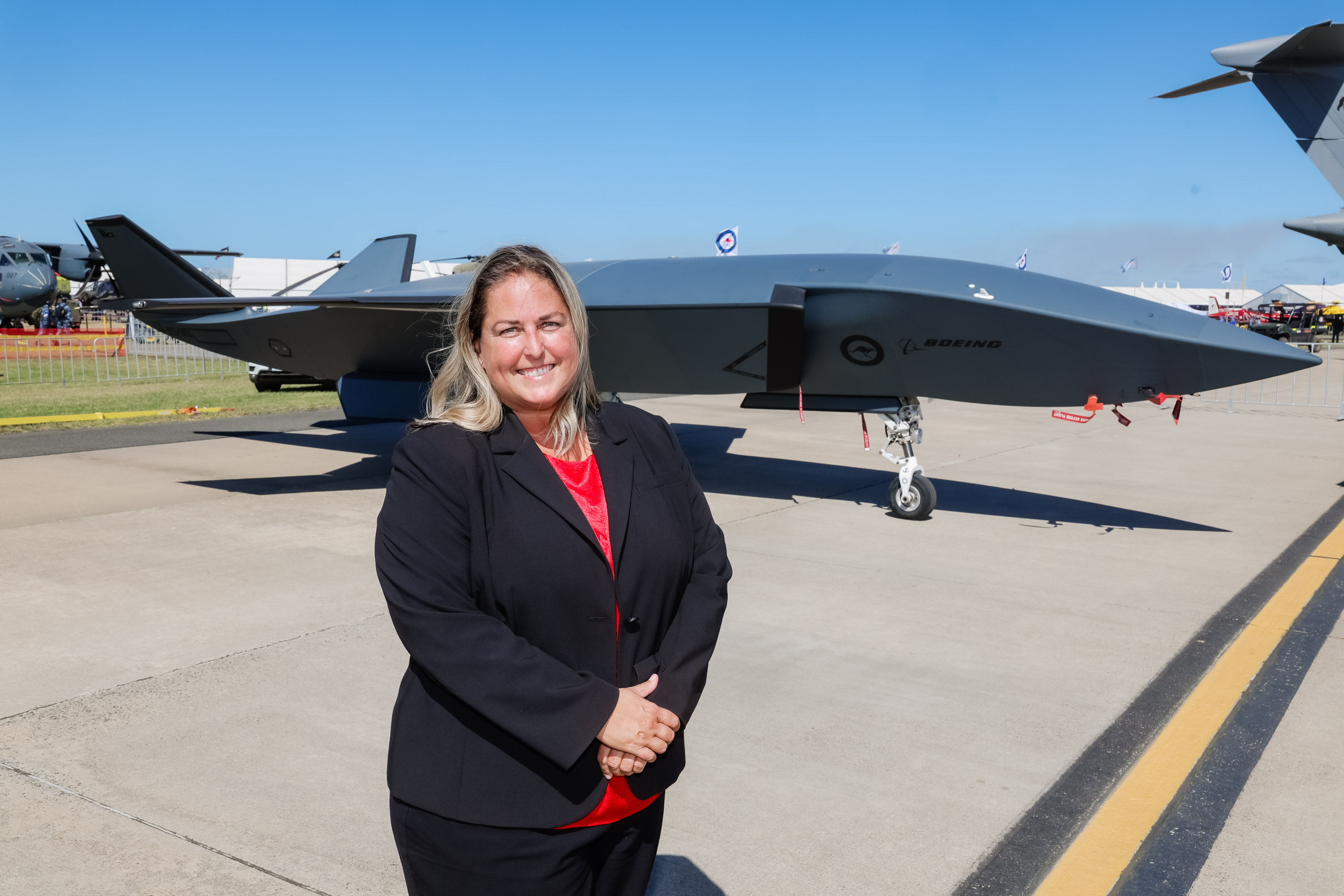 Kisa Christensen in front of a Boeing MQ-28 Ghost Bat